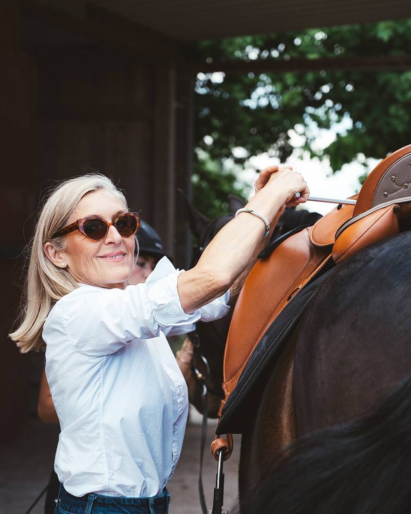 Jeanette Zehner beim Satteln eines Pferdes